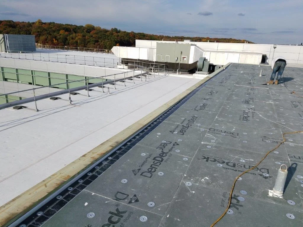 Commercial roofing contractor installing EPDM membrane on a flat roof in Amity Harbor, Long Island